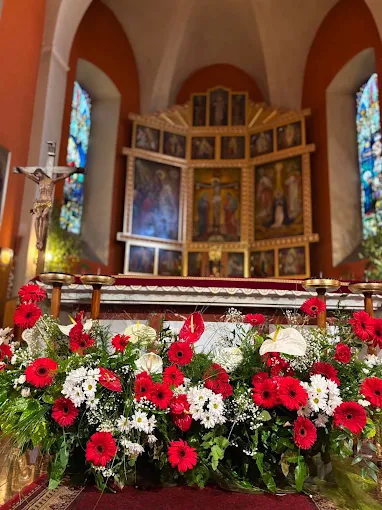 Kwiatowa dekoracja ołtarza z czerwonymi gerberami – florystyka ślubna Atelier Madeleine