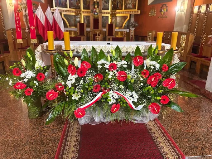 Dekoracja ołtarza czerwono-białymi kwiatami i świecami – florystyka ślubna Atelier Madeleine
